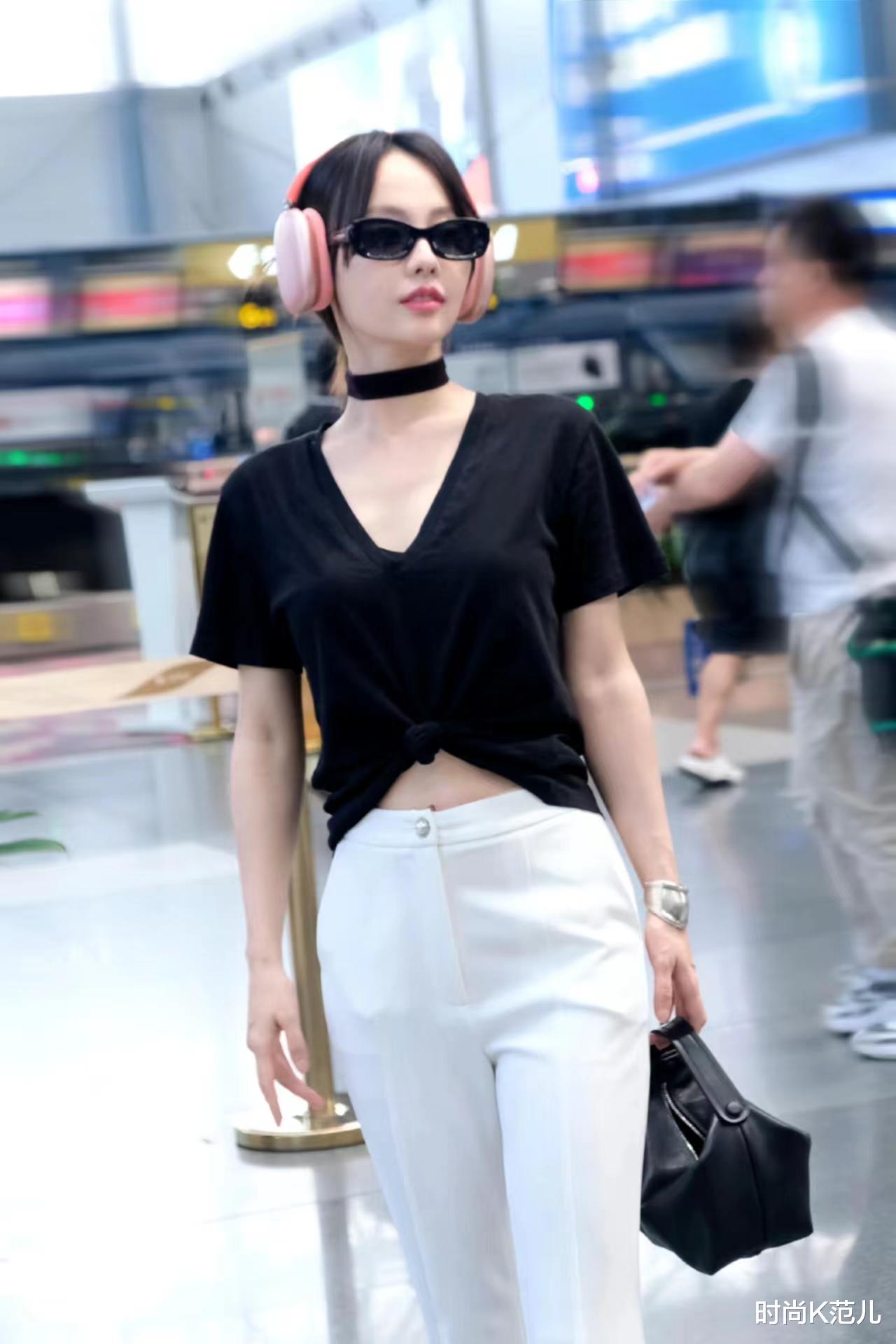 张嘉倪现身机场，黑色露脐上衣搭配白色长裤，简约时尚又显高！